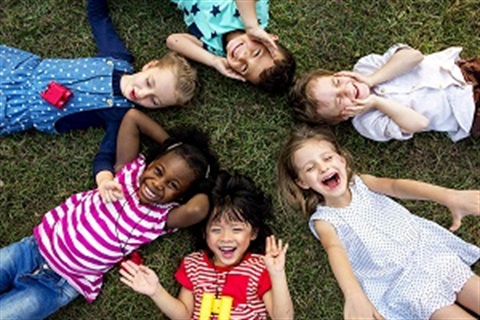 group of kindergarten children lying on the grass
