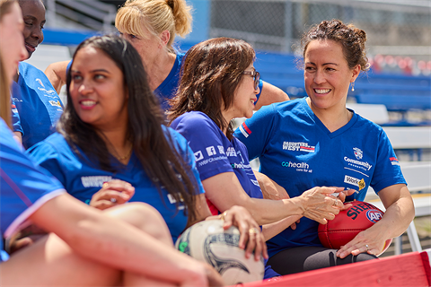 Women sitting together at an oval with a football